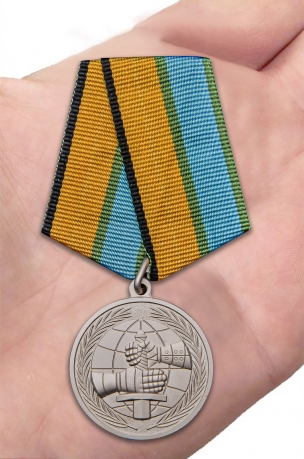 Латунная медаль МО РФ За вклад в развитие международного военного сотрудничества - вид на ладони