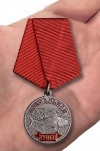 Латунная медаль Тунец - вид на ладони