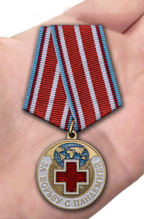 Латунная медаль За борьбу с пандемией - вид на ладони