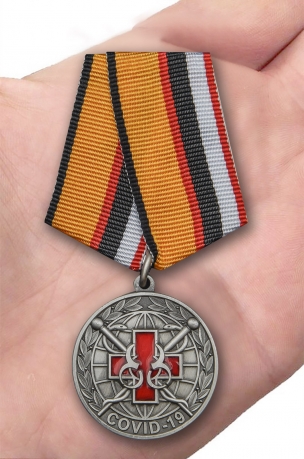 Латунная медаль За борьбу с пандемией COVID-19 - вид на ладони