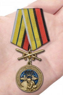 Латунная медаль За службу в артиллерийской разведке - вид на ладони