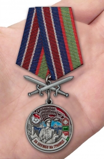 Латунная медаль За службу в Ребольском пограничном отряде - вид на ладони