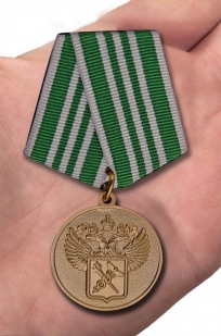 Латунная медаль За службу в таможенных органах 3 степени - вид на ладони