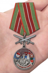 Латунная медаль За службу в Выборгском пограничном отряде - вид на ладони
