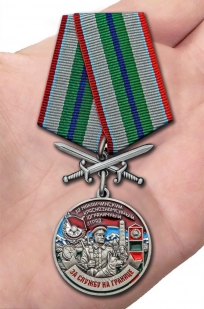 Латунная медаль За службу в Маканчинском пограничном отряде - вид на ладони