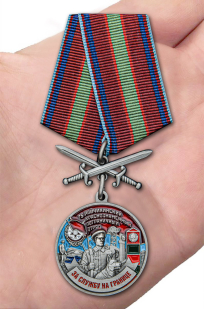 Латунная медаль За службу в Райчихинском пограничном отряде - вид на ладони