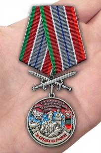 Латунная медаль За службу в Сосновоборском пограничном отряде - вид на ладони