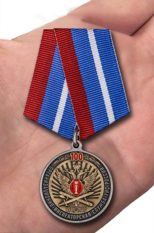 Медаль 100 лет Организационно-инспекторской службы УИС России на подставке - вид на ладони