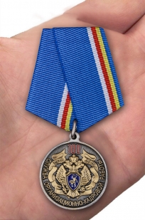 Медаль 100 лет Службе организационно-кадровой работы ФСБ России на подставке - вид на ладони