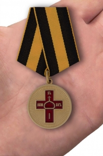 Медаль "Дело веры" в футляре из флока бордового цвета - вид на ладони
