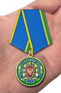 Медаль ФСБ РФ "За заслуги в пограничной деятельности" в бордовом футляре из бархатистого флока - вид на ладони
