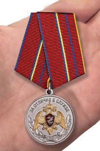 Медаль Росгвардии "За отличие в службе" 1 степень в нарядном футляре из бордового флока - вид на ладони