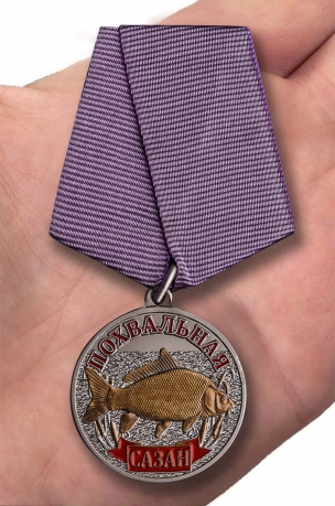 Медаль рыбаку Сазан на подставке - вид на ладони