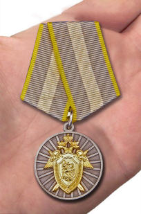 Медаль СК РФ "За отличие" в темно-бордовом футляре из флока - вид на ладони