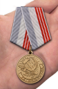 Медаль "Ветеран труда РФ" в бордовом футляре из бархатистого флока - вид на ладони