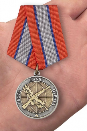 Медаль Ветерану боевых действий в нарядном футляре из бархатистого флока - вид на ладони